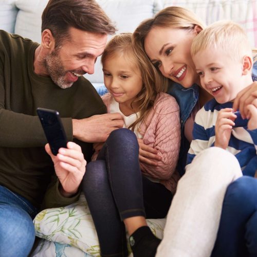 family-using-mobile-phone-in-living-room-2021-08-30-02-11-58-utc